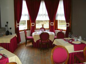 ジャレにあるB&B Le Petit Normandのダイニングルーム(テーブル、椅子、赤いカーテン付)