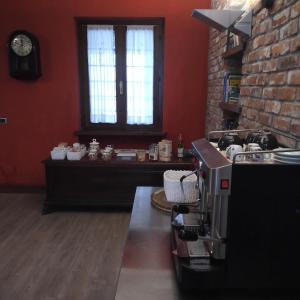 una cucina con macchinetta del caffè su un bancone di B&B Cascina Baraggione a Granozzo con Monticello