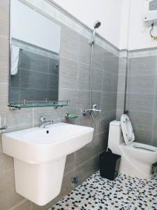 ein Badezimmer mit einem Waschbecken, einem WC und einem Spiegel in der Unterkunft AKU HOUSE Villa Ao vua in Ba Vì