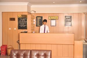 Un homme debout derrière un comptoir dans un restaurant dans l'établissement Serenti Hotel, à Giresun