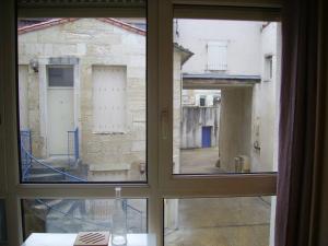 une fenêtre avec vue sur une cour extérieure dans l'établissement Appart Hôtel L'Angélique, à Niort