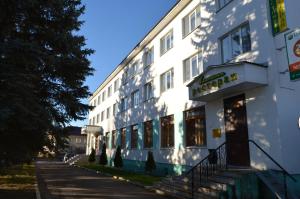 a white building with stairs next to a street at Hotel Planeta in Pechory