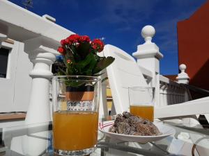 een glas sinaasappelsap en een bord eten op een tafel bij Teno Mountains&Bananas Garden House in Los Silos