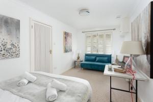 Habitación blanca con cama y sofá azul en Price & Weeks - Heart of Bath, en Bath