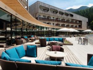 ein Gebäude mit blauen Sofas und Tischen auf einer Terrasse in der Unterkunft Travel Charme Bergresort Werfenweng in Werfenweng