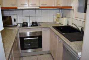a small kitchen with a sink and a microwave at casa con amarre privado ref 214 in Empuriabrava