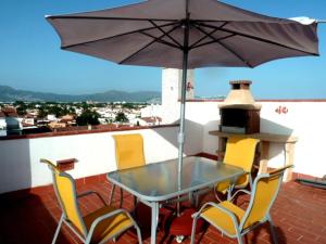 a patio table with chairs and an umbrella on a roof at apartamento con terraza vistas canal ref 238 in Empuriabrava