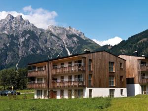 a building with mountains in the background at aja Bergresort Werfenweng in Werfenweng