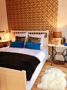 a bedroom with a large white bed with blue pillows at Ferienwohnung Sternstube De Luxe in Bad Harzburg