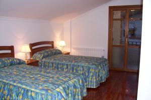 een hotelkamer met 2 bedden en 2 lampen bij Angoiko Etxea in Bacáicoa
