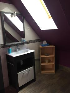 a bathroom with a sink and a mirror at L’escale du Bohain in Nassandres