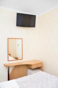 1 dormitorio con espejo y escritorio con cama en Guest House PARTIA, en Stavropol