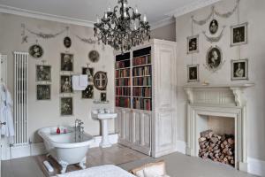 a bathroom with a chandelier and a tub and a fireplace at The Old Rectory in Hastings