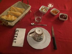 una mesa con un plato con una taza de té y pan en L’escale du Bohain, en Nassandres