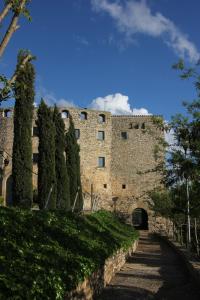 a large stone building with a tunnel and trees at Castell de Fonolleres in Fonolleres