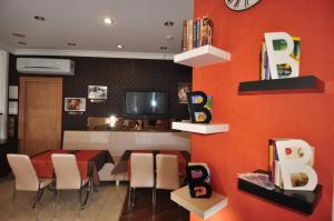 a dining room with a table and chairs and a tv at Mini Hotel in İzmir