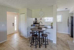 a kitchen with a table and stools in a room at La Casa Del Mar 610 Star5Vacations in Dunedin