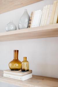 two bottles sitting on books on a shelf at Casa Pancha in Mexico City