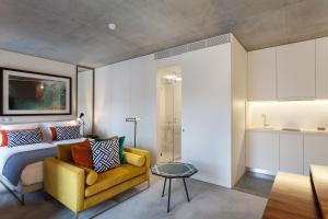 una camera con un letto e un divano giallo di S.Bento Residences a Porto