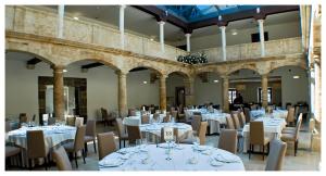 a banquet hall with white tables and chairs at Hotel Palacio de Merás in Tineo