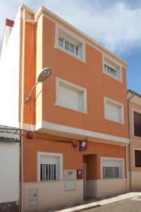 an orange building with windows and a street at Casa Rural Casole in Castalla