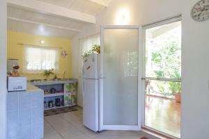 a kitchen with a white refrigerator in a room at Entre Dos Aguas in Coyuca