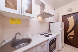 a kitchen with a sink and a stove and refrigerator at Home-otel in Krasnodar