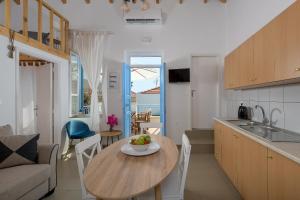 una cucina e un soggiorno con tavolo in legno in una camera di Anastasia house a Calchi (Halki)