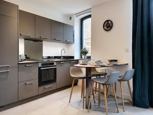 a kitchen with a table and chairs and a clock on the wall at La Viralamande by Cocoonr in Crépieux-la-Pape