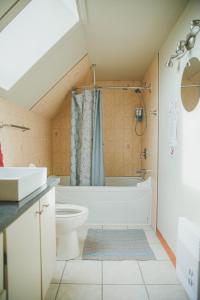 y baño con bañera, aseo y lavamanos. en Gîte B&B - Aubergélit inc, en Saint-Jean-Port-Joli
