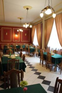 uma sala de jantar com mesas e cadeiras verdes em Hotel Europejski em Przemyśl