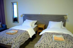 two beds sitting next to each other in a room at Kartanohotelli Saari in Reisjärvi