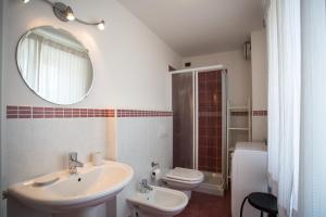 uma casa de banho com um lavatório, um WC e um espelho. em Casa Knapp em Lavarone