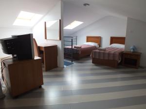 ein Hotelzimmer mit 2 Betten und einem TV in der Unterkunft Residence Lavanda in Umag