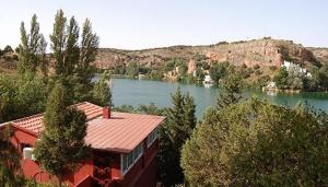 un edificio con vistas a un río y a una casa en La Buena Siesta, en Ruidera