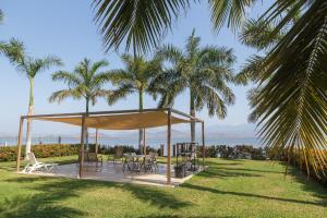 a gazebo in the grass with palm trees at Entre Dos Aguas in Coyuca