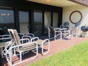 a patio with chairs and tables and a grill at Suntide I Condos W102 in South Padre Island