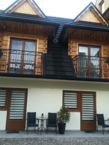 a building with a table and chairs in front of it at Apartamenty U Samków in Zakopane