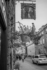 a black and white photo of a street with a plant at Hotel Maison du Général in Quebec City