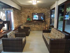 a lobby with couches and a tv in a building at Marinas Pousada in Ilhéus
