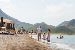 a group of people walking on a beach at Hotel Savojo in Petrovac na Moru