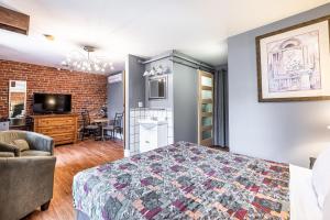 a bedroom with a bed and a living room at Hotel Maison du Général in Quebec City