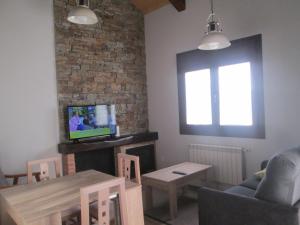 uma sala de estar com um sofá, uma televisão e uma mesa em APARTAMENTOS FONTE VILLAR em Navia