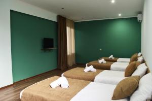 a room with four beds and a green wall at Taba Hall Boutique Hotel in Akhaltsikhe