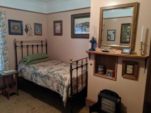 a bedroom with a bed and a mirror at Gower Manor Historic Bed & Breakfast in St. John's