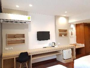 a room with a desk and a tv on a wall at Florida Hotel in Bangkok