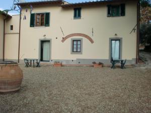 una gran casa blanca con dos bancos delante en Il Palagetto, en Bagno a Ripoli