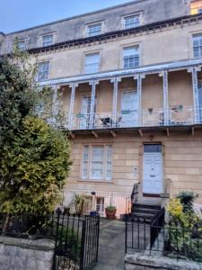 una vecchia casa con porta bianca e balcone di MyCityHaven South Parade Mansions a Bristol