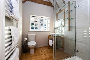 a bathroom with a toilet and a glass shower at Pages Hotel and Guesthouse in Harlow