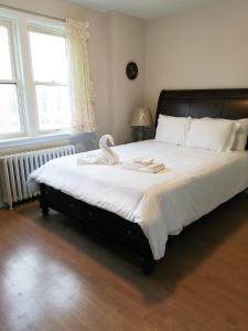 a bedroom with a large bed with white sheets at Cozy Private Rm Heart of North York Free Parking Full Kitchen Close to Downtown in Toronto